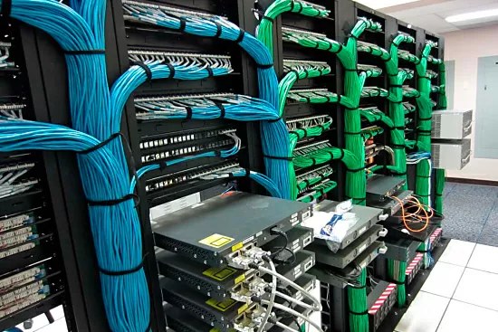 a server room or network cable rack representing bandwidth and storage costs of transmitting encoded data